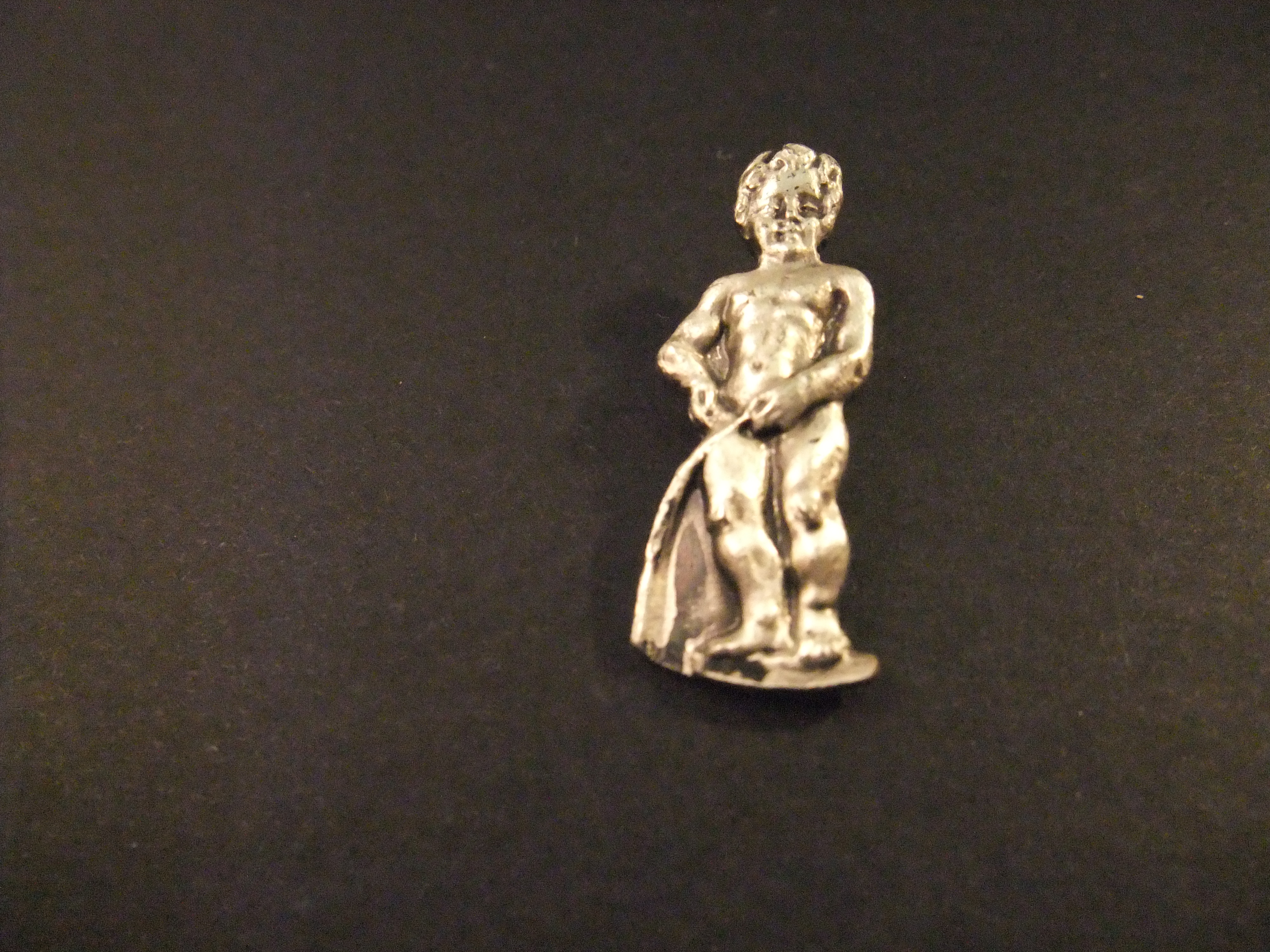 Manneken Pis  standbeeldje van een plassend jongetje in het centrum van Brussel ( zilverkleurig